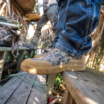 Man standing in a duck blind with Camp Shoes on