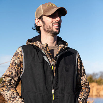 Man looking into the distance in a black Gator Waders Flyway Vest