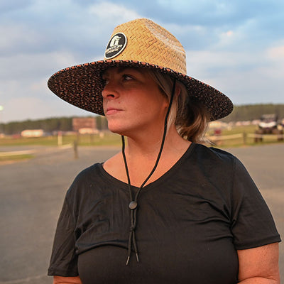 woman standing in leopard straw hat