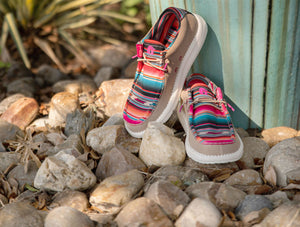 A pair of Gator Waders shoes sitting on rocks. The shoes are Camp Shoes and are a Serape pattern.